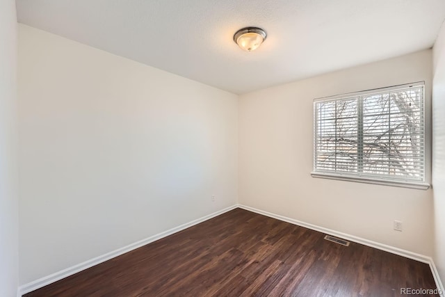 unfurnished room with dark hardwood / wood-style flooring