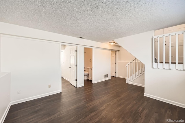 interior space featuring dark hardwood / wood-style flooring and a textured ceiling