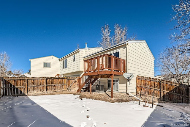 snow covered property with a deck and central AC unit