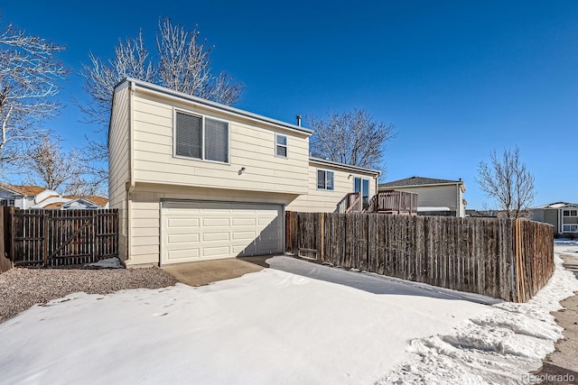 snow covered property with a garage