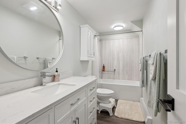 full bathroom featuring vanity, hardwood / wood-style floors, washtub / shower combination, and toilet