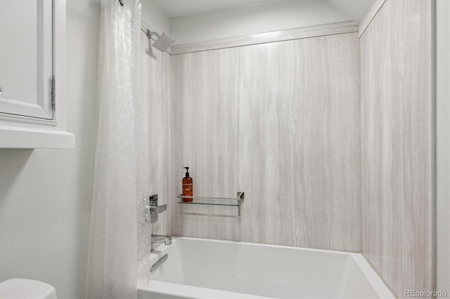 bathroom featuring shower / tub combination and toilet