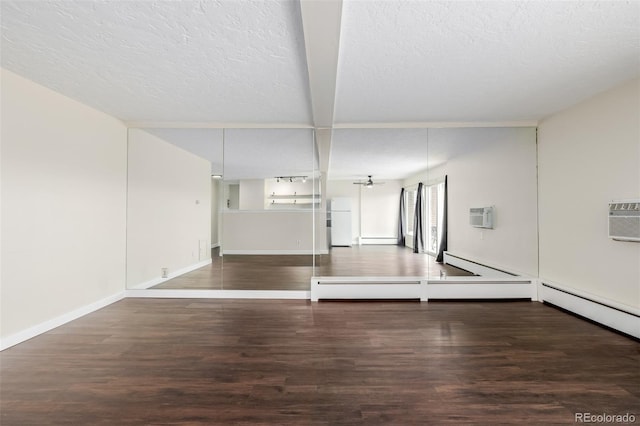 unfurnished room featuring a baseboard heating unit, dark hardwood / wood-style floors, a wall mounted air conditioner, and a textured ceiling