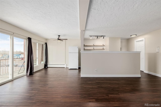 empty room featuring ceiling fan, a baseboard radiator, dark hardwood / wood-style floors, and a textured ceiling