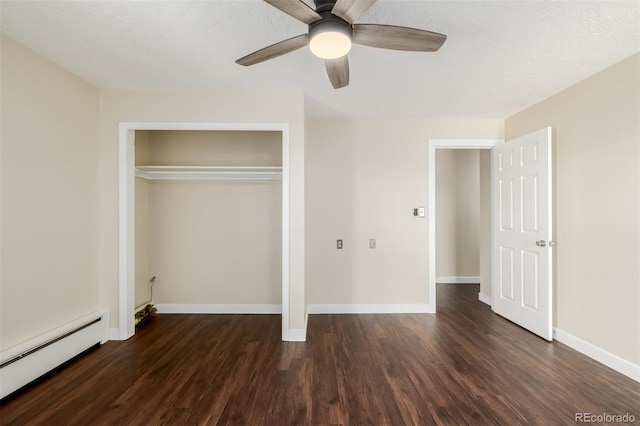 unfurnished bedroom with dark hardwood / wood-style flooring, ceiling fan, baseboard heating, and a closet