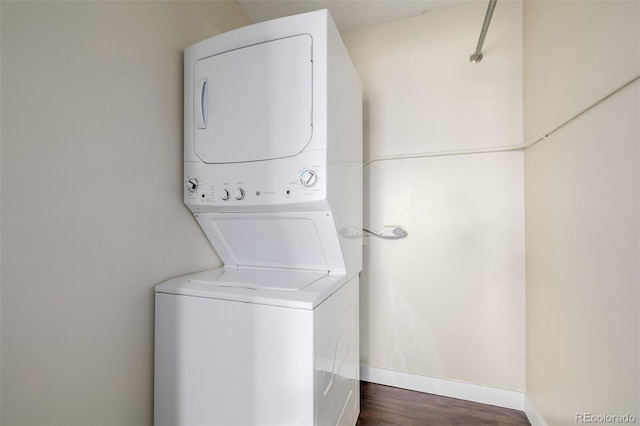 laundry area featuring stacked washer / dryer and dark hardwood / wood-style floors