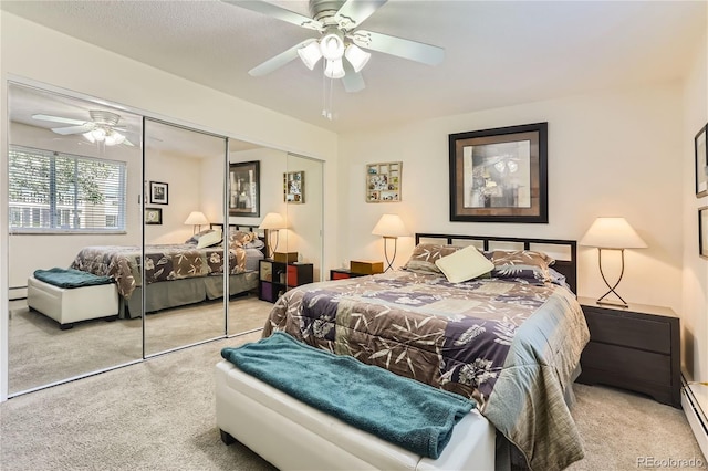 bedroom with a baseboard heating unit, light colored carpet, ceiling fan, and a closet