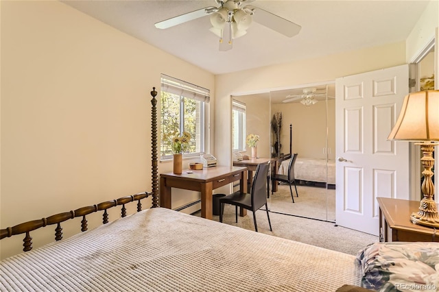 carpeted bedroom with a baseboard heating unit, a closet, and ceiling fan