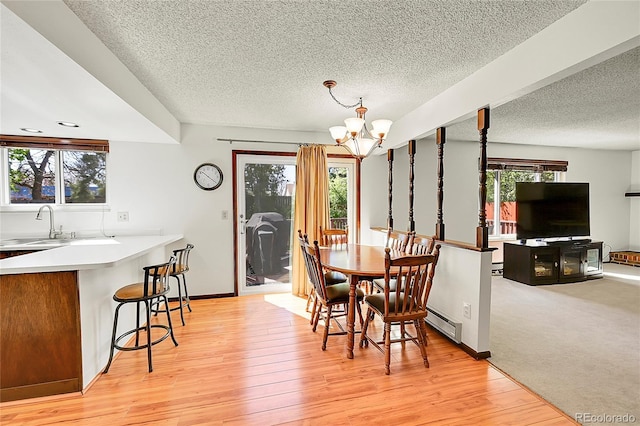 dining space with an inviting chandelier, plenty of natural light, and a textured ceiling