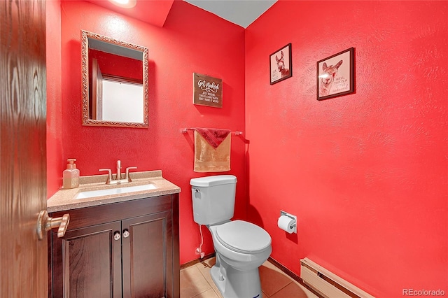 bathroom with tile patterned floors, baseboards, vanity, a baseboard heating unit, and toilet