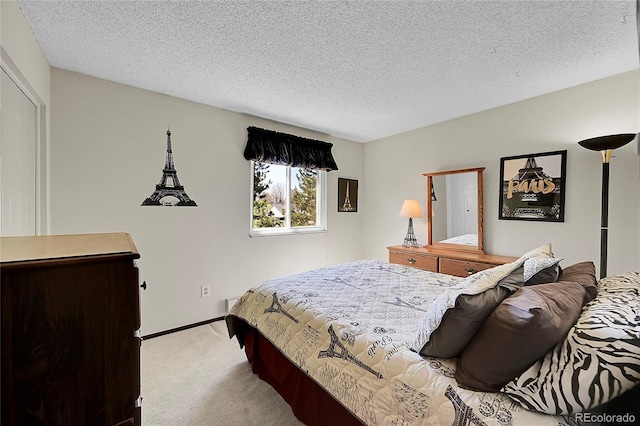 carpeted bedroom with a textured ceiling and baseboards