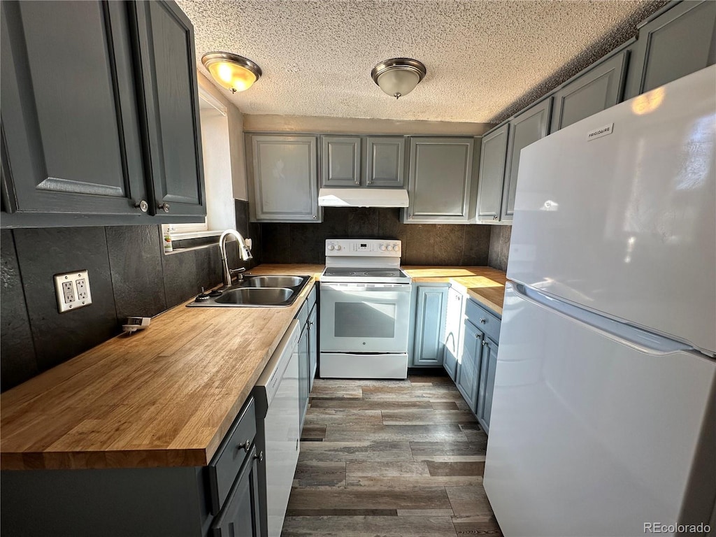 kitchen with butcher block countertops, sink, gray cabinetry, and white appliances