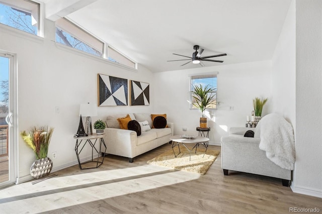 living area with a wealth of natural light, ceiling fan, baseboards, and wood finished floors