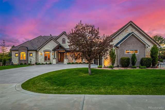 french country inspired facade with a lawn