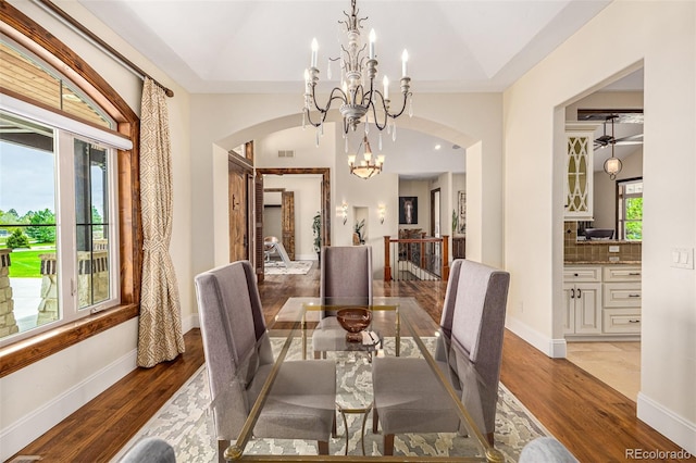 dining room featuring dark hardwood / wood-style flooring, a raised ceiling, and a notable chandelier