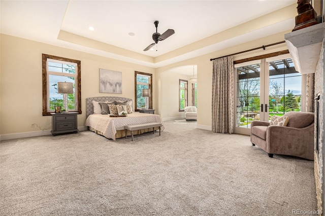 bedroom featuring a raised ceiling, ceiling fan, french doors, and carpet floors