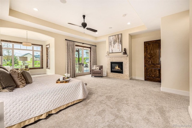 bedroom with carpet floors, ceiling fan, a raised ceiling, and access to exterior