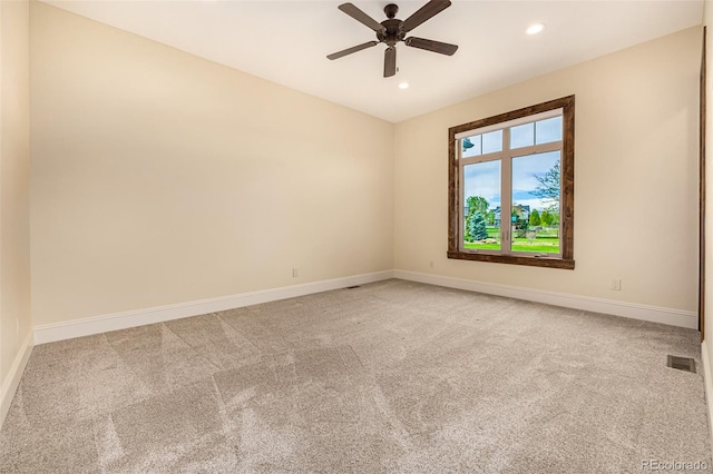 unfurnished room with ceiling fan and carpet