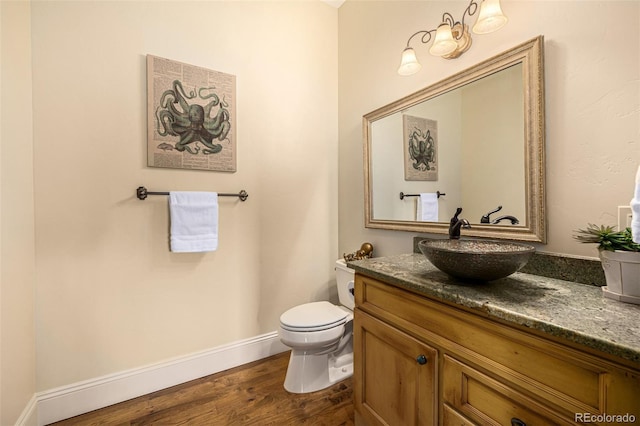 bathroom featuring wood-type flooring, vanity, and toilet