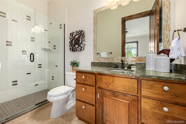 bathroom featuring large vanity, ceiling fan, toilet, an enclosed shower, and tile floors