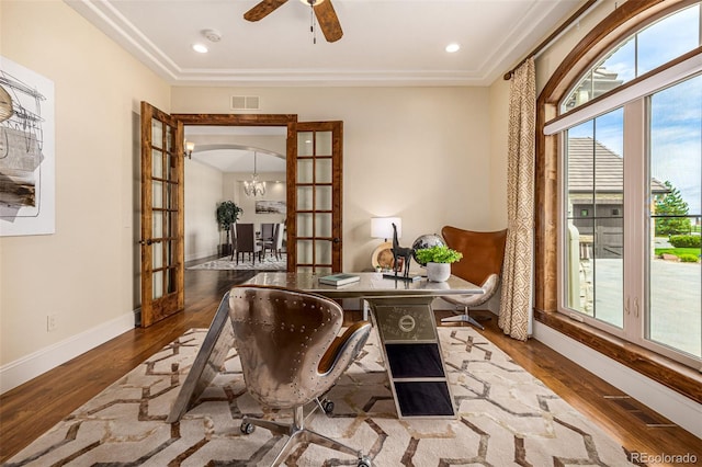 living area featuring ceiling fan with notable chandelier, a healthy amount of sunlight, dark wood-type flooring, and french doors