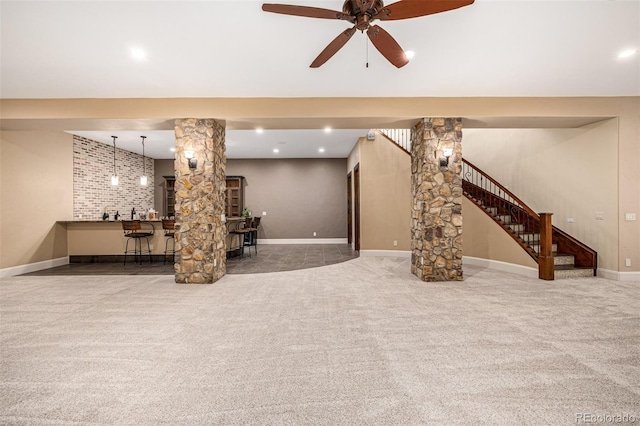 unfurnished living room featuring ornate columns, carpet floors, and ceiling fan