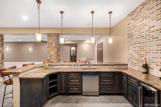 kitchen with hanging light fixtures, a kitchen bar, light stone countertops, and beverage cooler