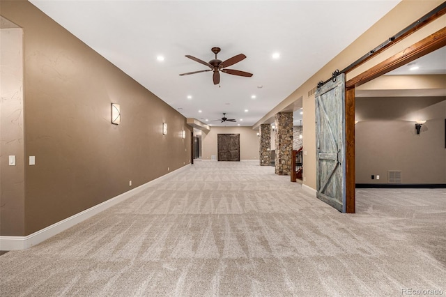 interior space with ceiling fan and a barn door