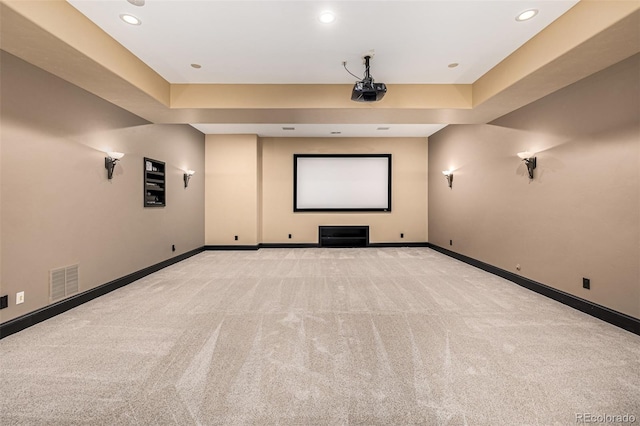 carpeted home theater with a raised ceiling