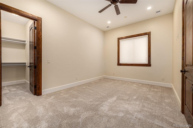 unfurnished bedroom featuring a closet, a spacious closet, ceiling fan, and carpet floors