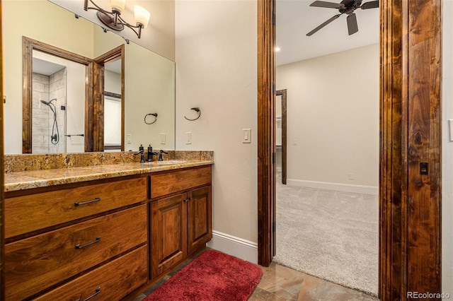 bathroom featuring tile floors, ceiling fan, a tile shower, and large vanity