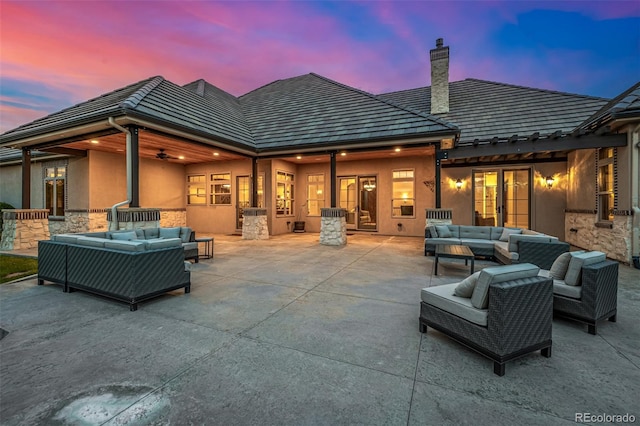 back house at dusk featuring a patio area and an outdoor hangout area