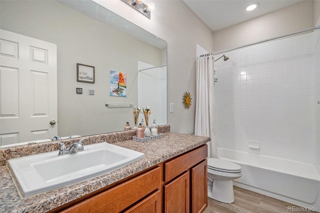 full bathroom featuring vanity, wood-type flooring, shower / bath combo, and toilet