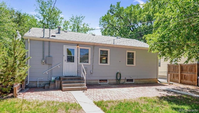 rear view of house with a patio area, entry steps, and fence