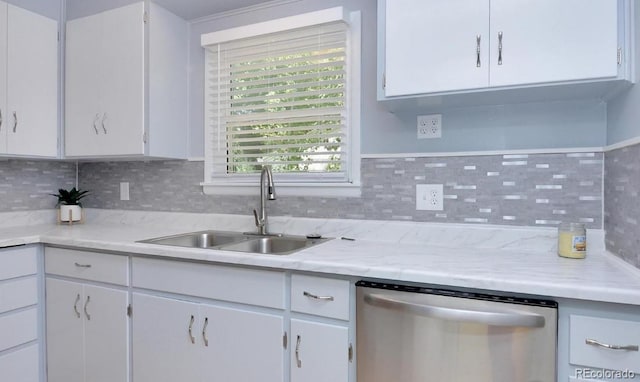kitchen with white cabinets, dishwasher, a sink, light countertops, and backsplash
