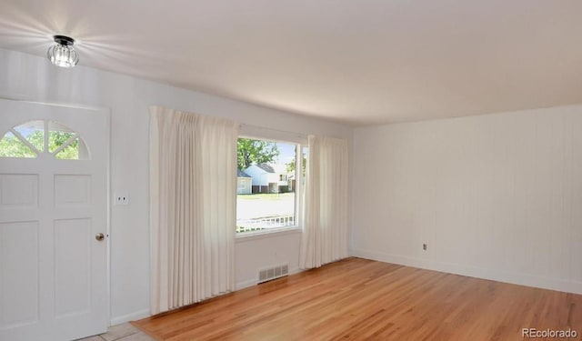 foyer with visible vents, baseboards, and light wood-type flooring