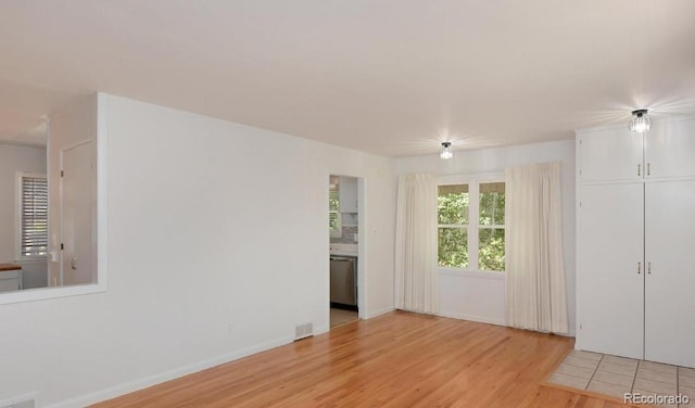 unfurnished room featuring light wood-style floors, baseboards, and visible vents