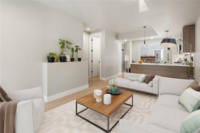 living area with recessed lighting, light wood-style flooring, visible vents, and baseboards