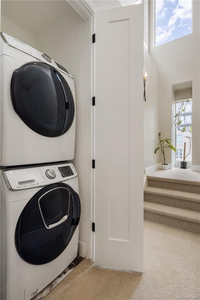 washroom featuring stacked washing maching and dryer, laundry area, and carpet