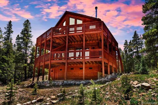 back house at dusk with a wooden deck