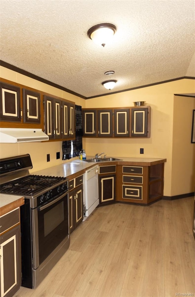 kitchen with dishwasher, gas range, ornamental molding, light wood-type flooring, and a textured ceiling