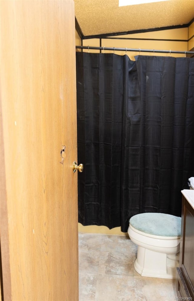 bathroom featuring vanity, toilet, and a textured ceiling