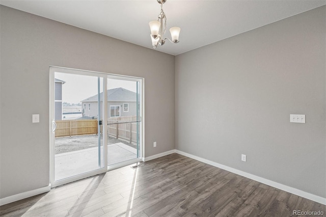 13466 Valentia St, Thornton, CO 80602 - spare room with a chandelier, baseboards, and wood finished floors