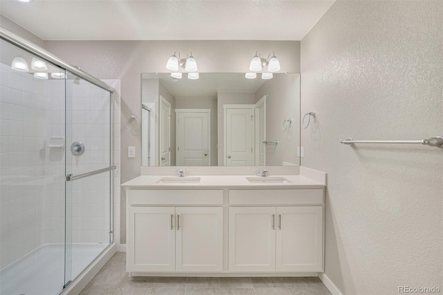 13466 Valentia St, Thornton, CO 80602 - bathroom with a textured wall, a shower stall, double vanity, and baseboards