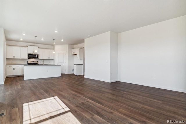 kitchen featuring dark hardwood / wood-style floors, black range, and a kitchen island with sink