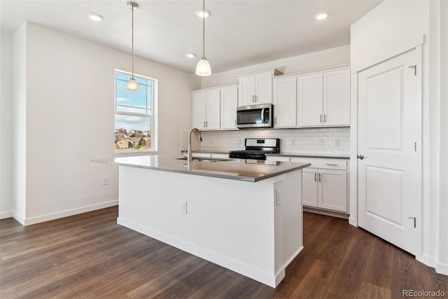 kitchen with white cabinets, a center island with sink, sink, and appliances with stainless steel finishes