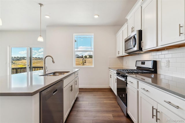 kitchen featuring white cabinetry, sink, appliances with stainless steel finishes, decorative light fixtures, and dark wood-type flooring