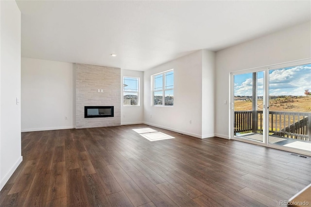 unfurnished living room featuring dark wood-type flooring and a fireplace