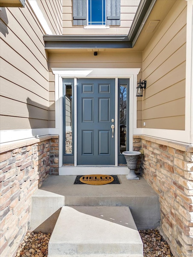 doorway to property featuring stone siding