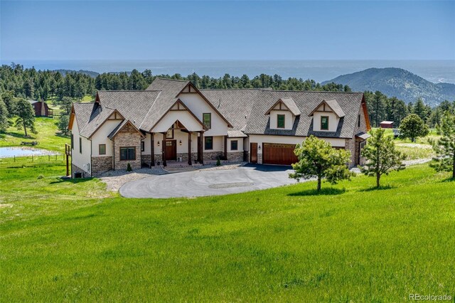 view of front facade featuring a water view, a front lawn, and a garage